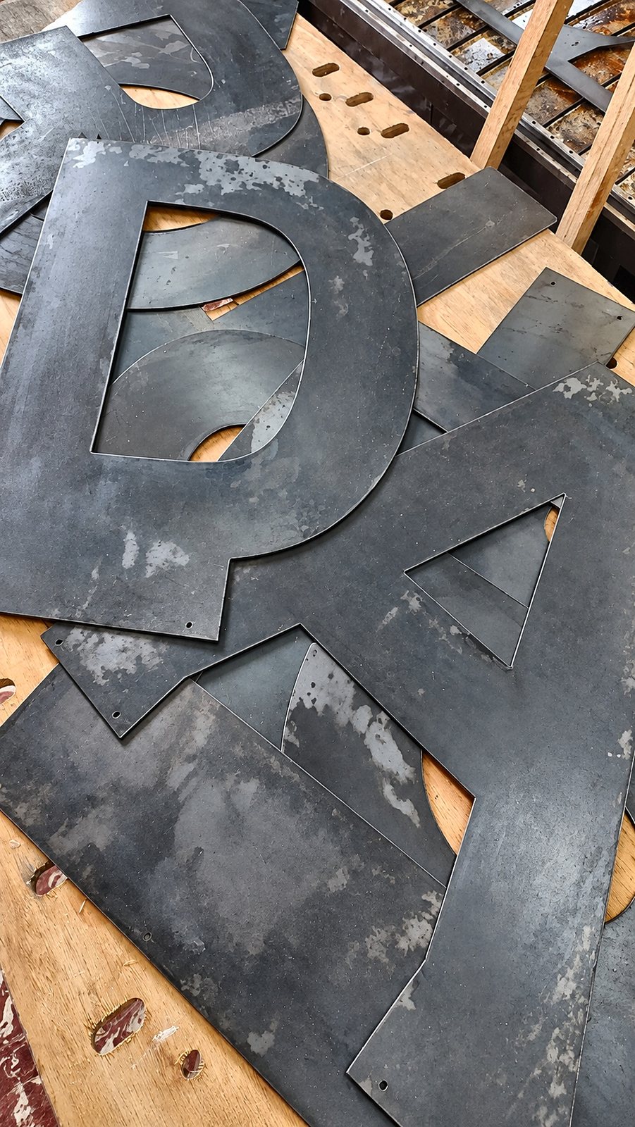 Letras cortadas en chapa sobre la mesa del plasma.